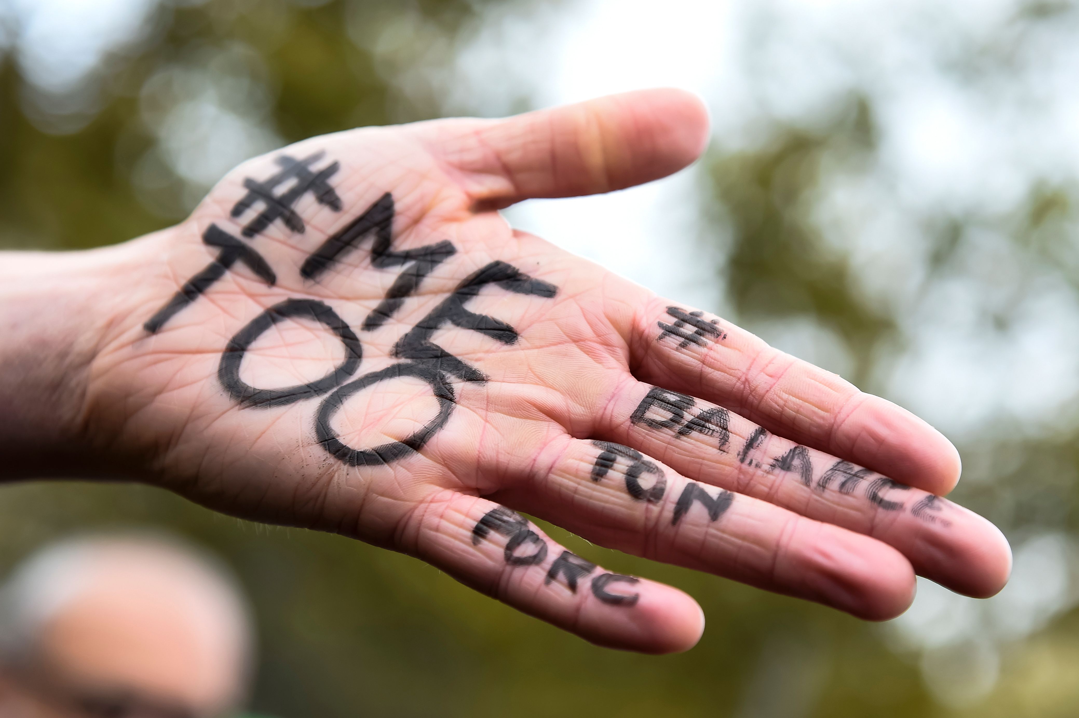A picture shows the messages "#Me too" and #Balancetonporc ("expose your pig") on the hand of a protester during a gathering against gender-based and sexual violence called by the Effronte-e-s Collective, on the Place de la Republique square in Paris on October 29, 2017. #MeToo hashtag, is the campaign encouraging women to denounce experiences of sexual abuse that has swept across social media in the wake of the wave of allegations targeting Hollywood producer Harvey Weinstein. / AFP PHOTO / BERTRAND GUAY (Photo credit should read BERTRAND GUAY/AFP/Getty Images)